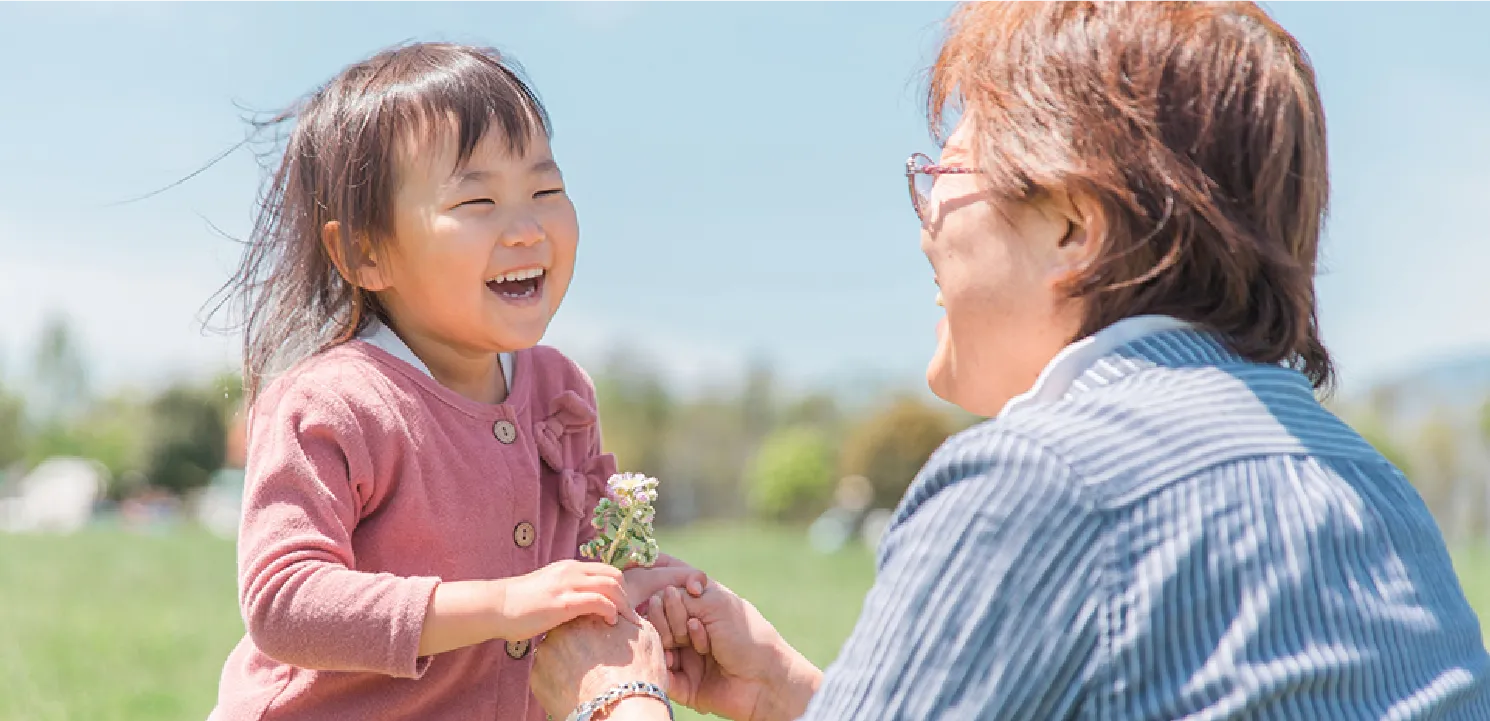 年配女性が子供と遊んでいる画像